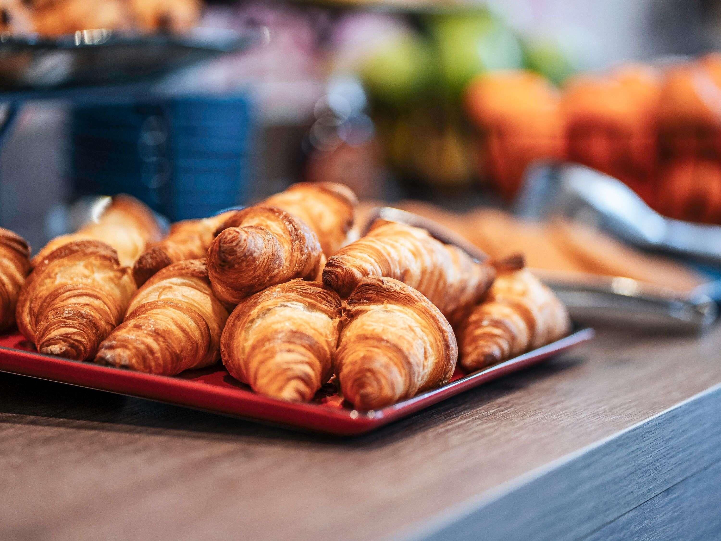 A tray of croissants on a red plate.