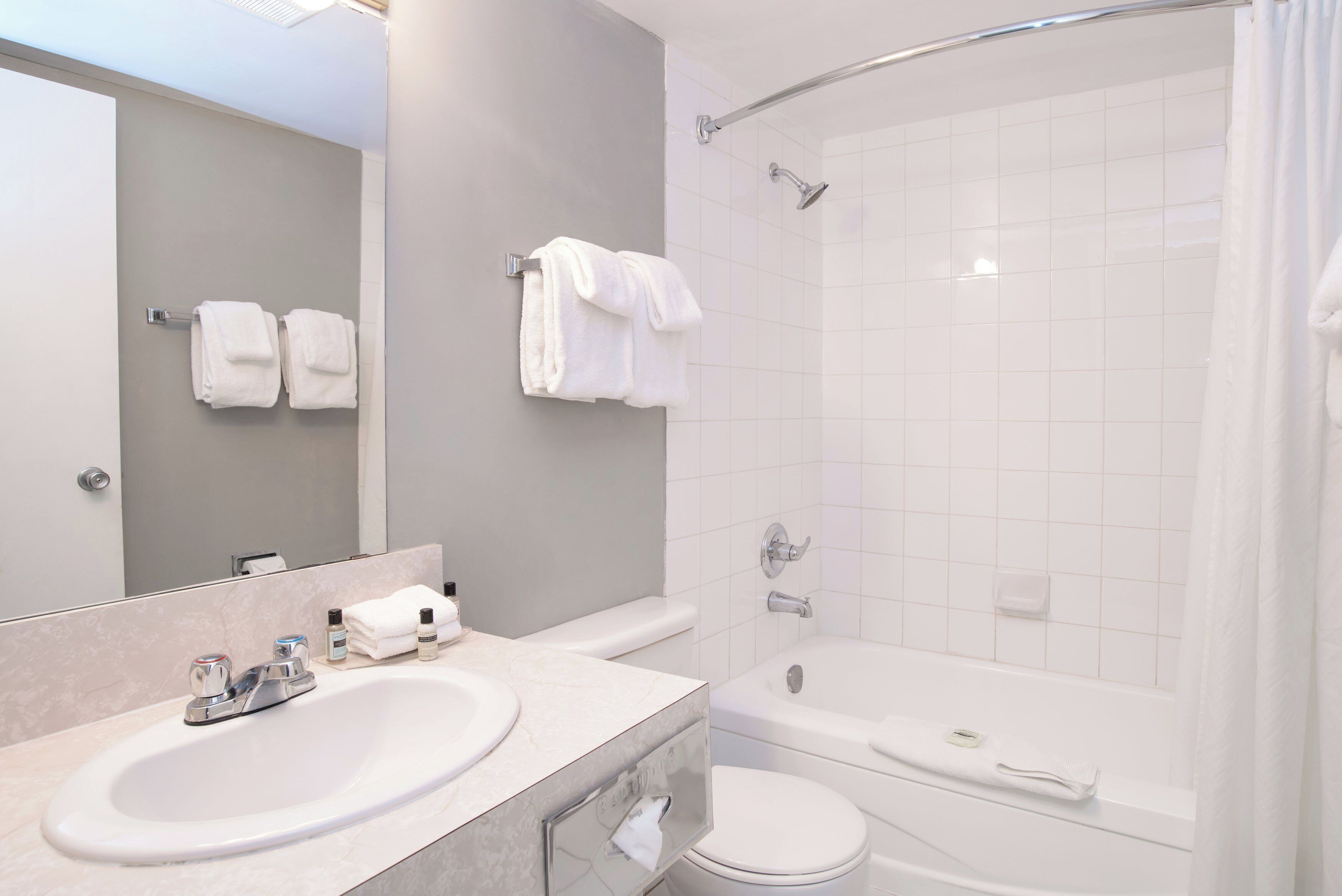 Un baño moderno con lavabo, espejo y zona de ducha.