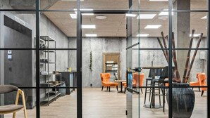 A modern interior with glass partitions, a kitchen area, and seating arrangements. - Best Western Royal Holstebro (Holstebro)