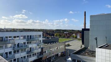 Urban landscape with a mix of residential and commercial buildings, featuring a green space and industrial structures.