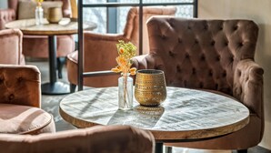 A round wooden table with a vase of dried flowers and a textured lamp. - Best Western Royal Holstebro (Holstebro)