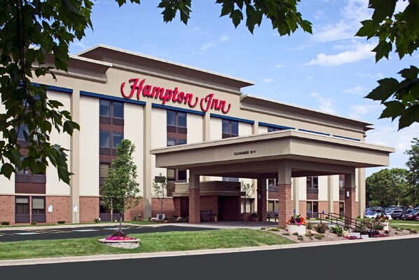 Un hôtel Hampton Inn doté d’une entrée bien visible, d’un parking couvert et d’un parterre aménagé à l’avant.