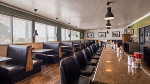A restaurant with booth seating, a long counter with condiment dispensers, and pendant lighting. - Best Western Paradise Inn & Resort (Fillmore)