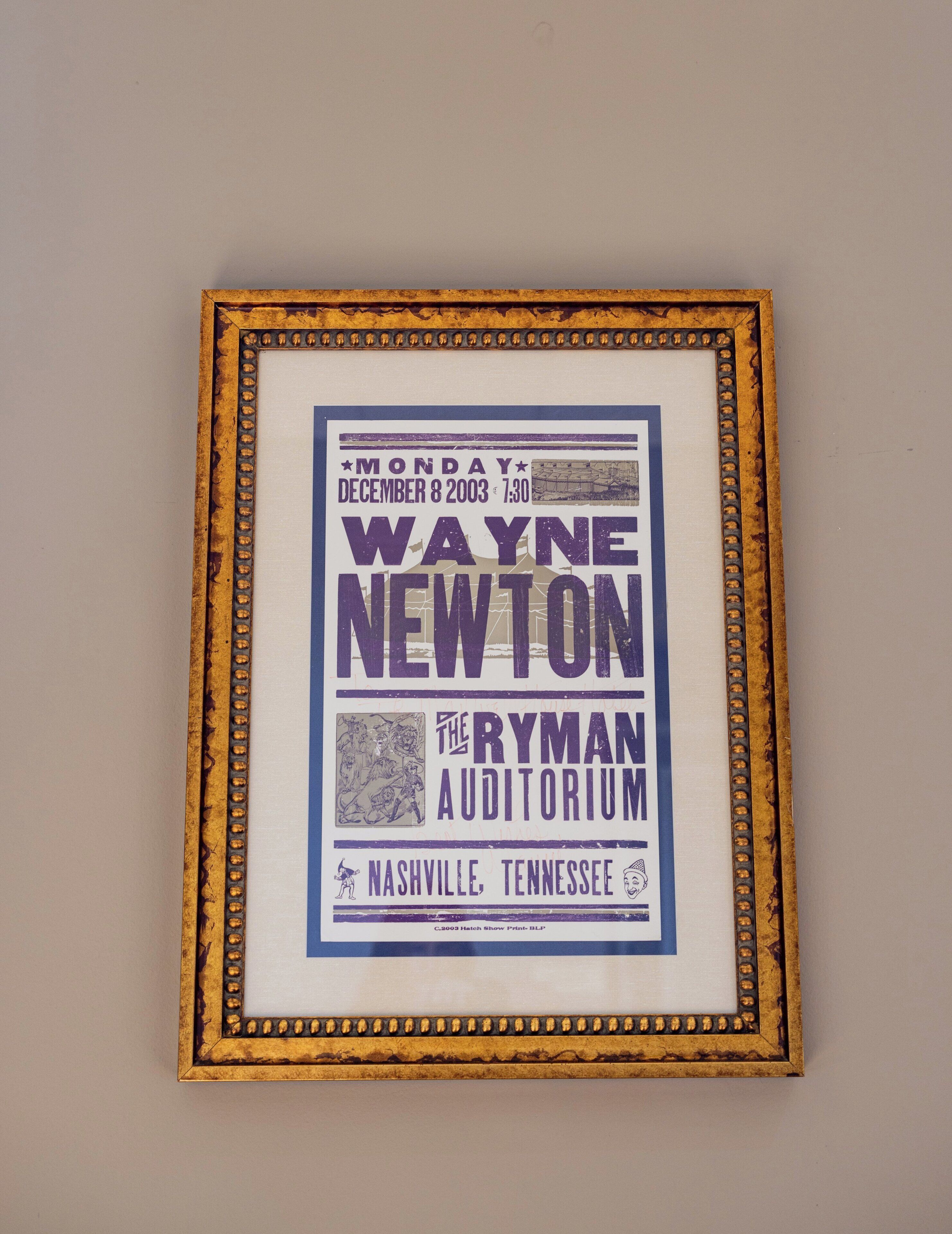 A framed poster with text and a map, indicating an event at The Ryman Auditorium in Nashville, Tennessee.