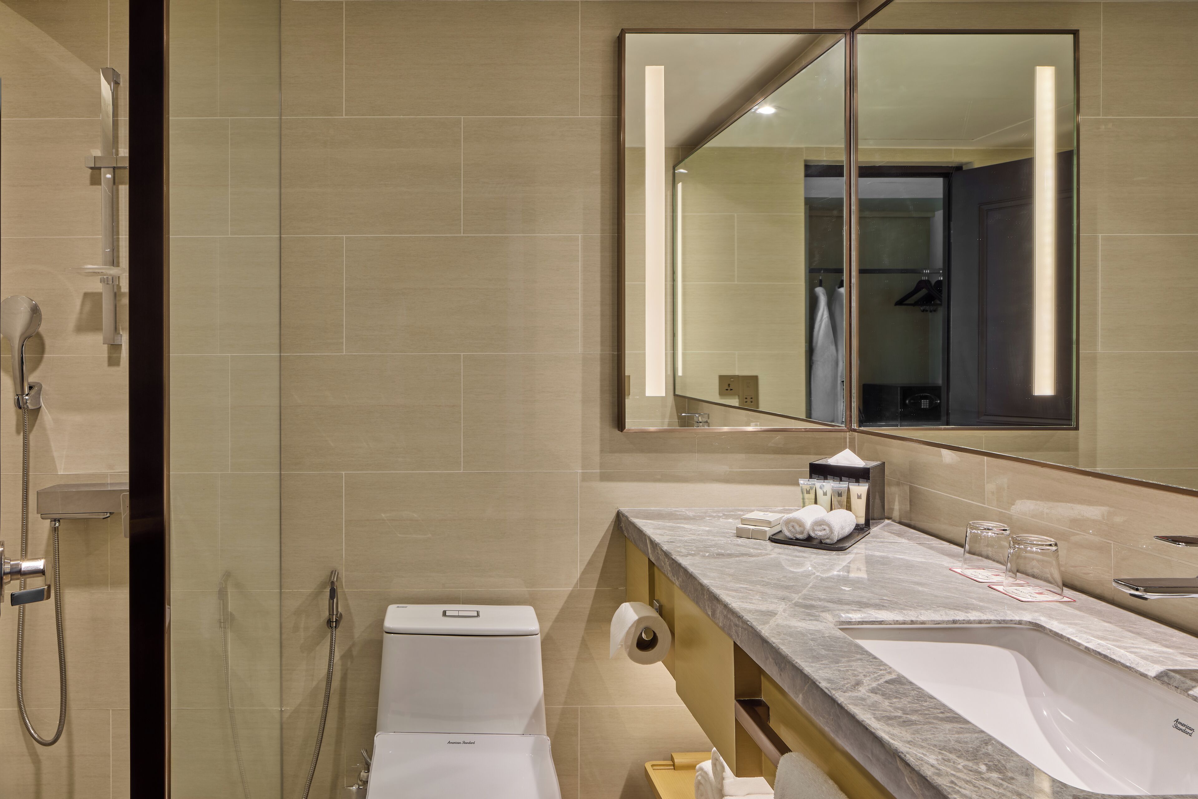A modern bathroom with a toilet, sink, and shower.