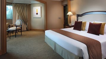 Habitación de hotel con una cama grande, una silla, un escritorio y una ventana con cortinas.