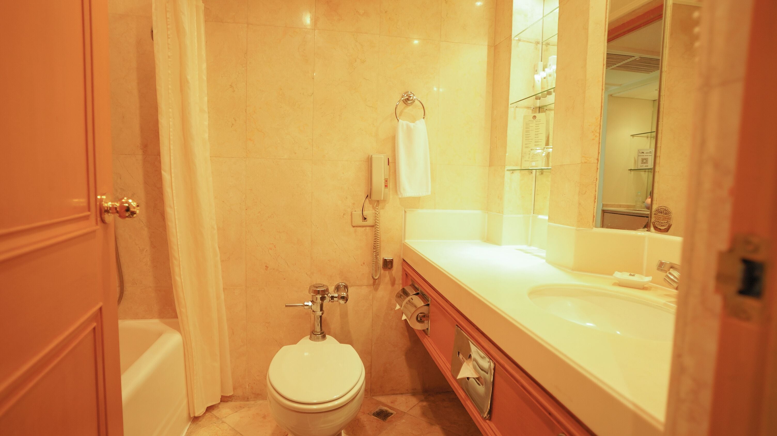 A bathroom with a toilet, sink, and shower.