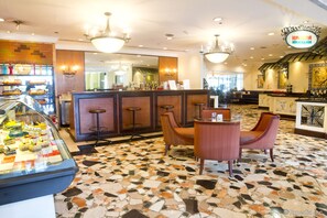 Relax in our spacious lobby, featuring a mosaic tile floor, comfortable seating, and a display case with sweet treats.