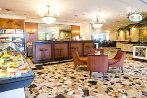Relax in our spacious lobby, featuring a mosaic tile floor, comfortable seating, and a display case with sweet treats.