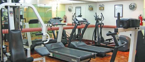Ein Fitnessstudio mit Laufbändern, Crosstrainern und Krafttrainingsgeräten.