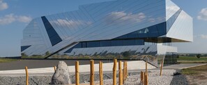 Een modern gebouw met een uniek, hoekig ontwerp en een spiegelende gevel.