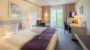 A hotel room with a large bed, a desk with a chair, a television, and a window with curtains. - Best Western Hotel Helmstedt am Lappwald (Helmstedt)