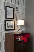 Een modern interieur met een houten kast, een stadsgezicht in een lijst en een tafellamp.