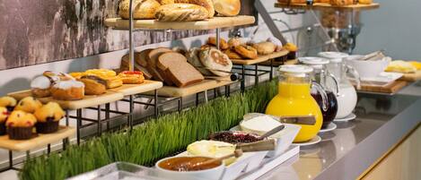 A buffet with various pastries, breads, and spreads.