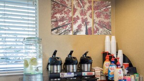 A kitchen counter with a coffee maker, a water dispenser, and various coffee pods. - Red Roof Inn PLUS+ Columbus - Dublin  (Dublin)