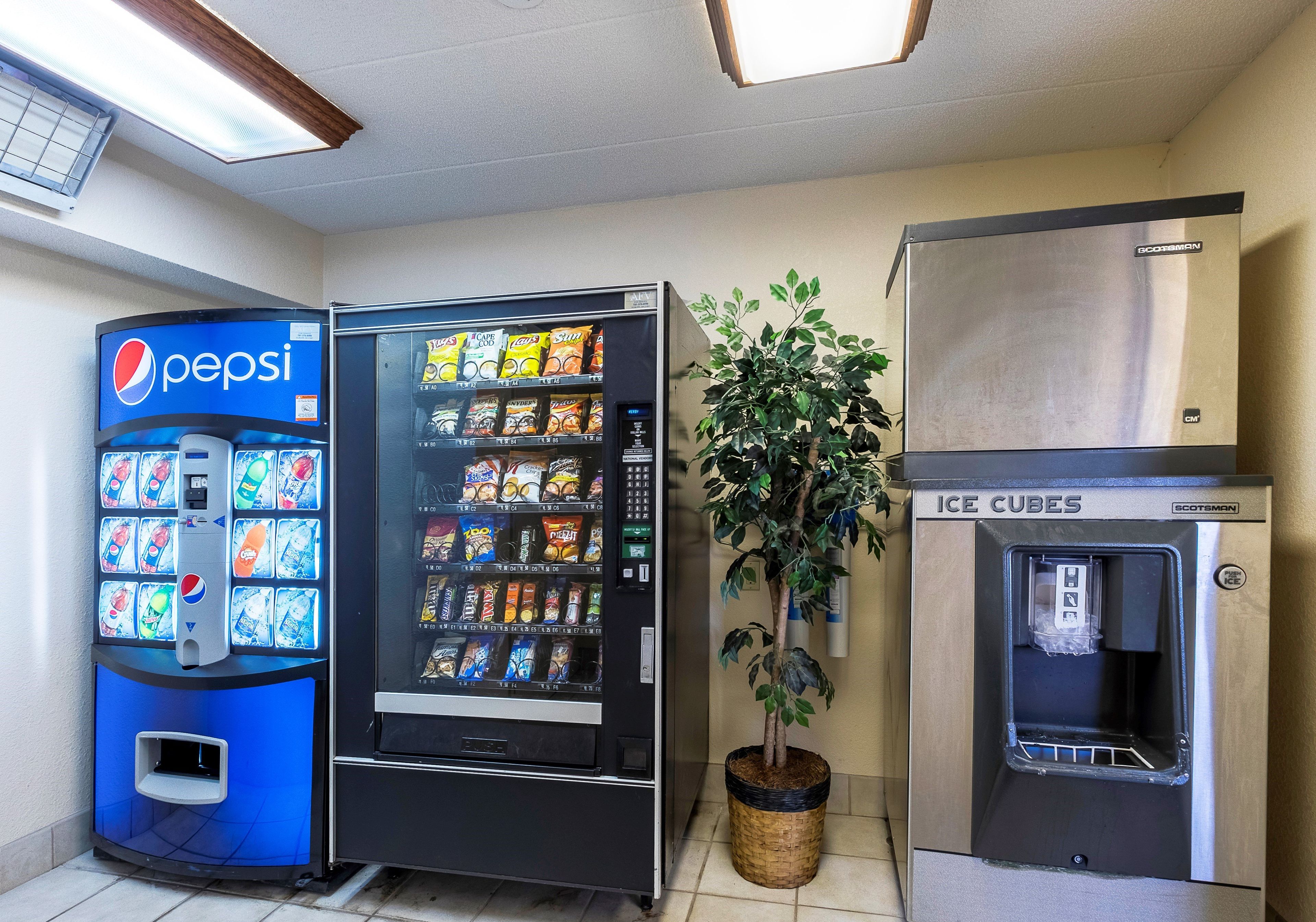Zona de máquinas expendedoras con una máquina de Pepsi, una máquina de aperitivos y un dispensador de hielo.