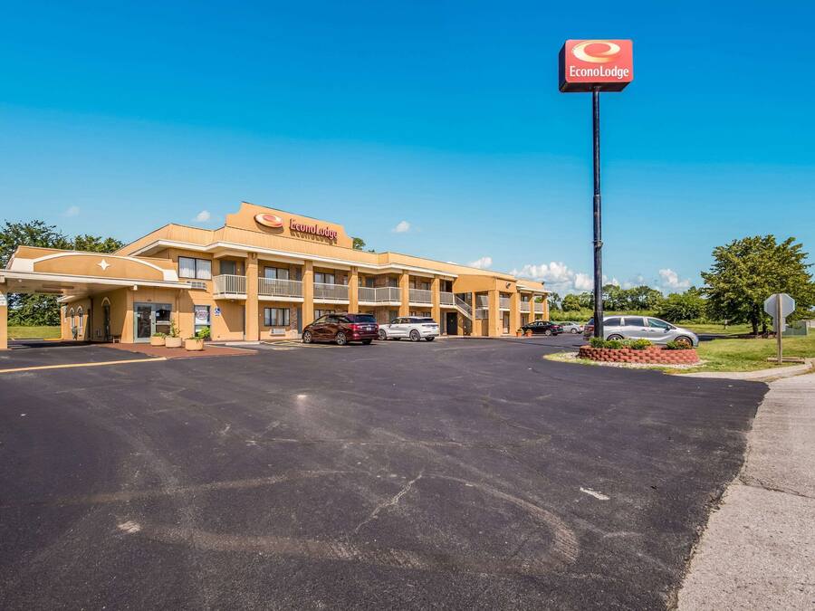 Un hotel con un cartel grande que dice "EconoLodge" y un estacionamiento con varios coches.
