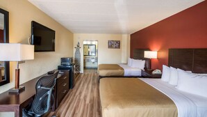 A hotel room with a bed, desk, chair, and a television on the wall. - Econo Lodge Kearney - Liberty (Kearney)
