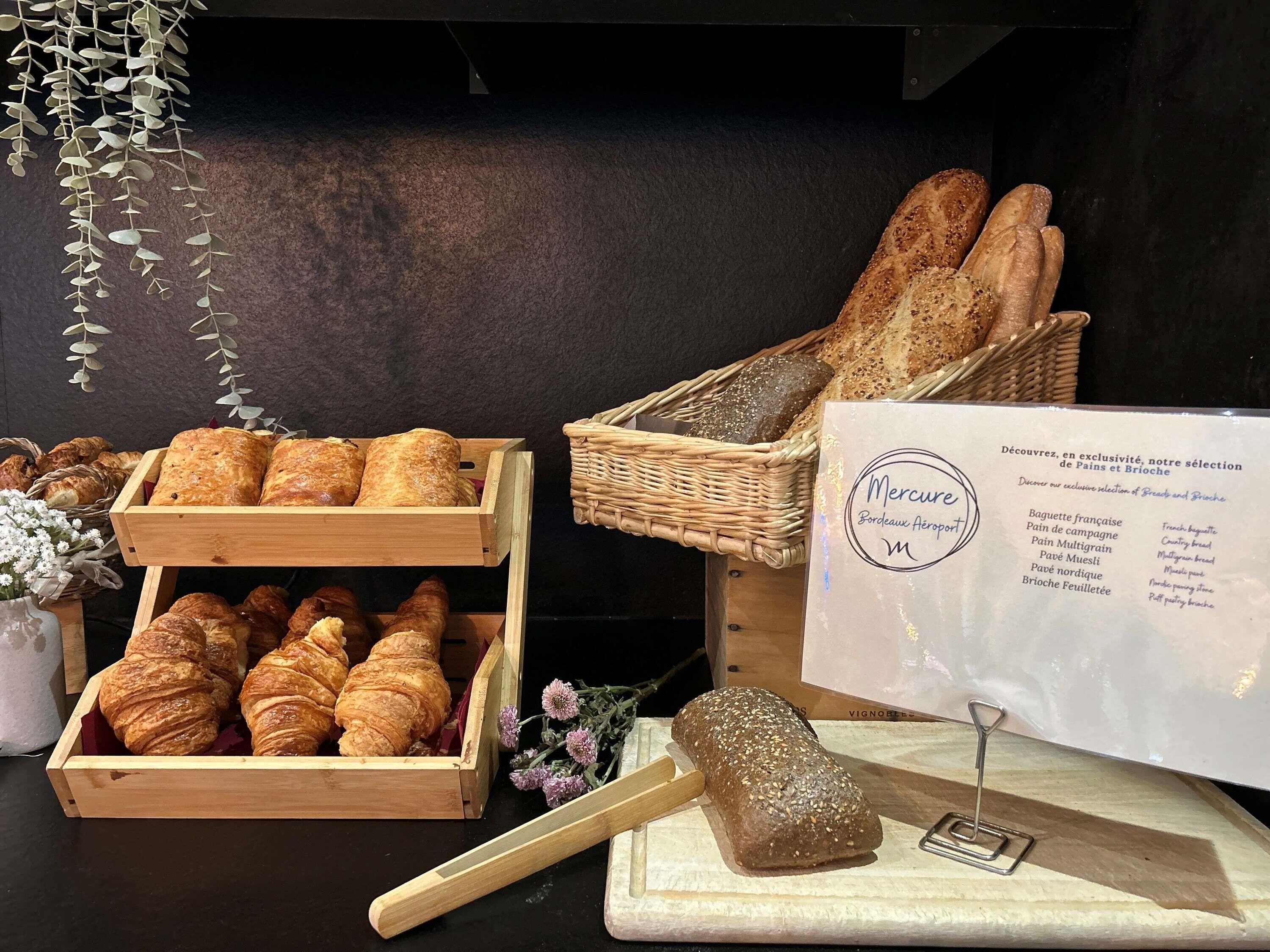 A bakery display with bread and pastries, a wicker basket, and a menu.
