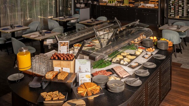 A buffet area with various food items and a juice dispenser.