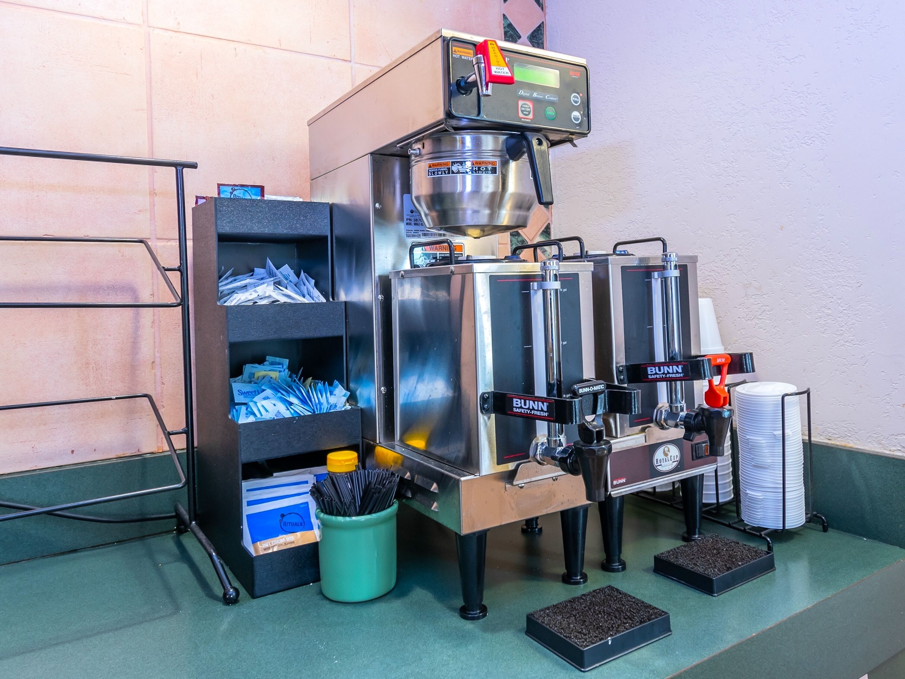 A coffee machine with a digital display, multiple dispensers, and a coffee bean storage area.