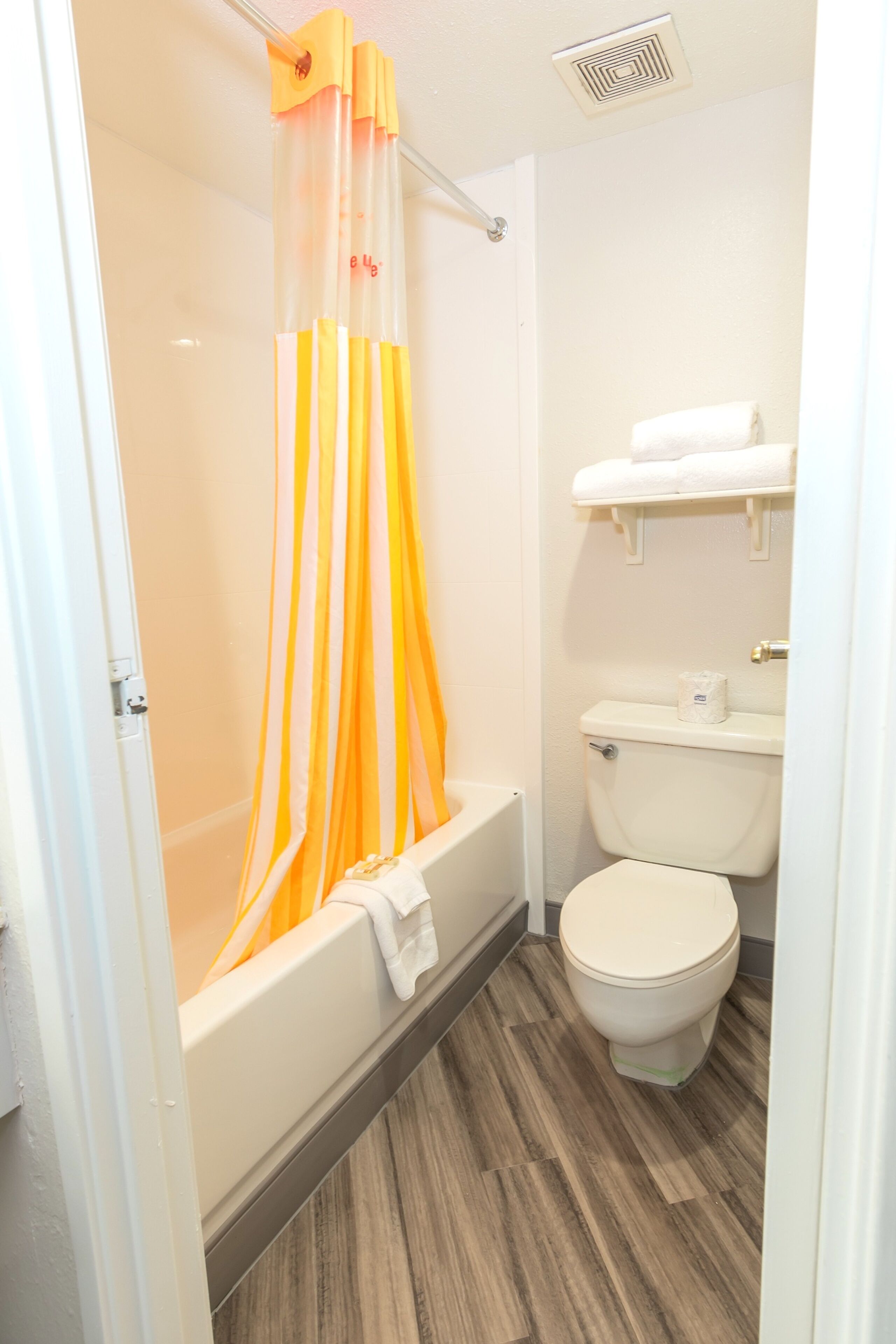 Un bagno con doccia, toilette e porta asciugamani.