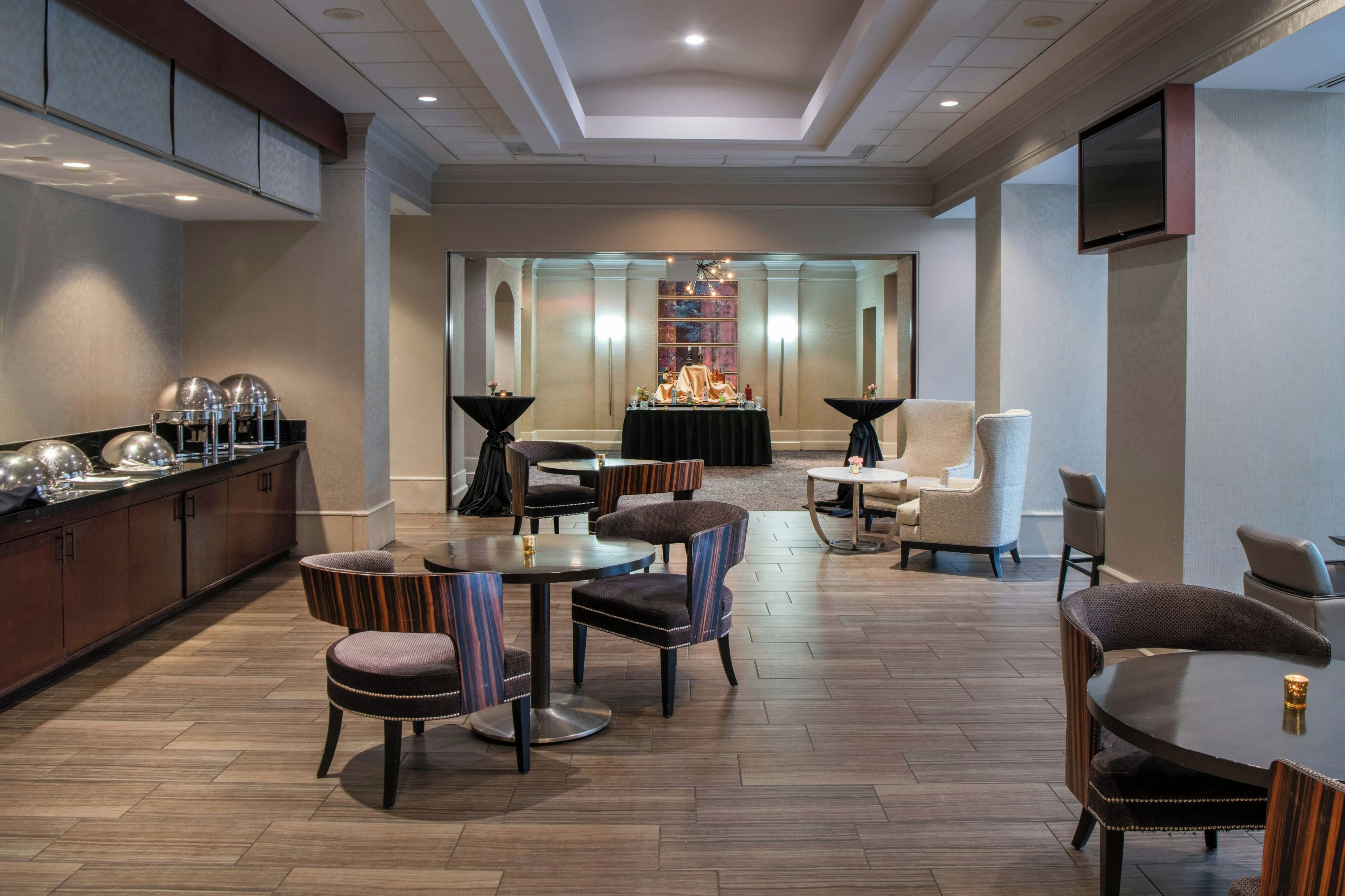 A hotel lobby with a reception desk, seating area, and a fireplace.