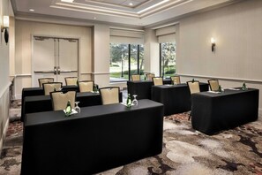 A conference room with multiple tables, chairs, and a projector screen. - Chicago Marriott Suites Deerfield (Deerfield)