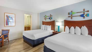 Une chambre d’hôtel avec deux lits, un plancher en bois, une chaise et un mur décoré.