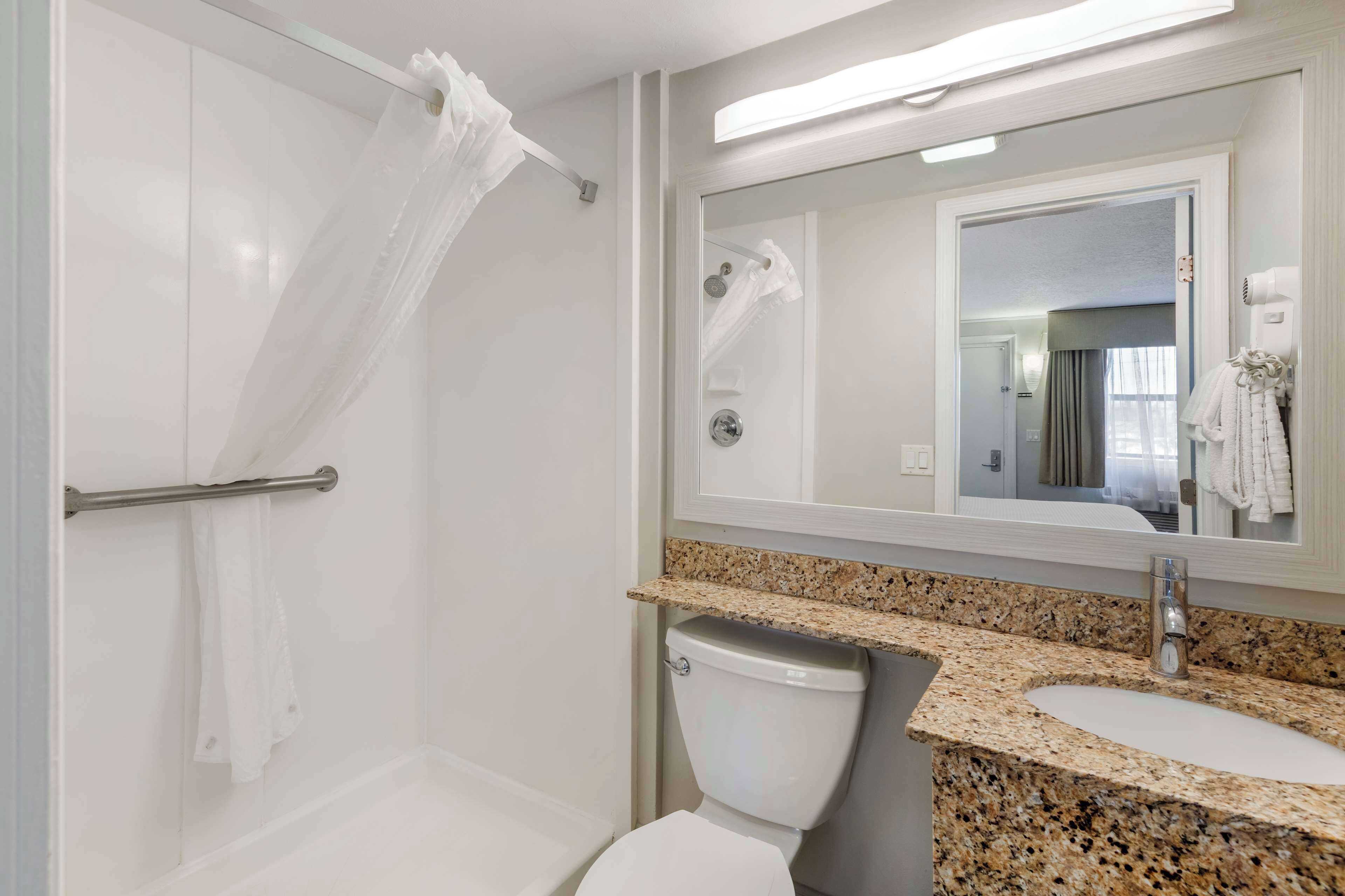 Un baño moderno con ducha, inodoro y lavamanos.