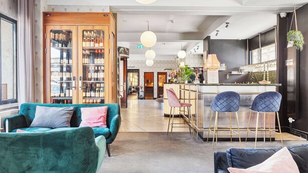 A modern hotel lobby with plush seating, a bar area, and a wine display. - Hotel Astoria, BW Signature Collection (Copenhagen)