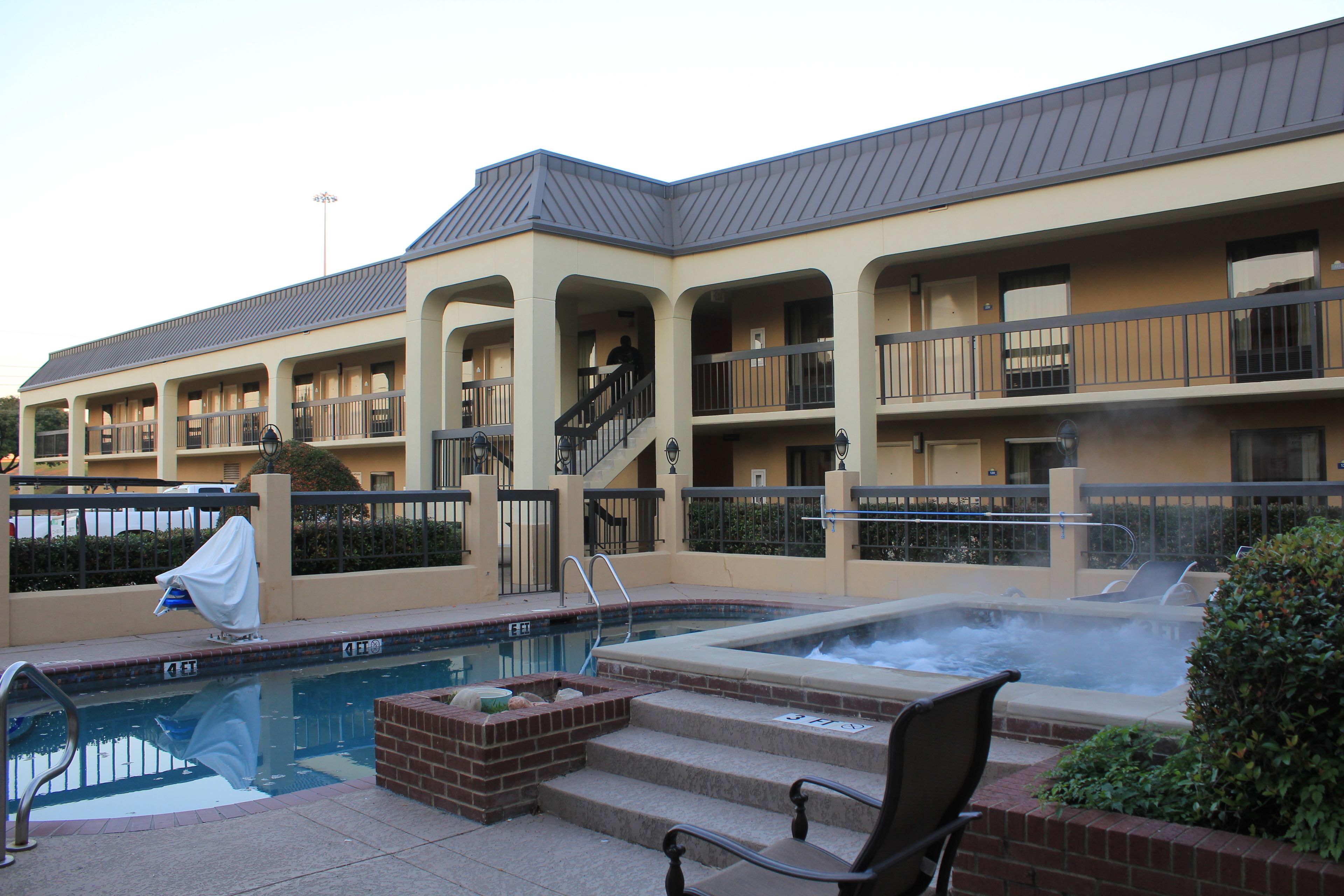 Un hotel con piscina, jacuzzi y zona de estar al aire libre.