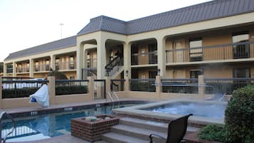Un hotel con piscina, jacuzzi y zona de estar al aire libre.