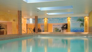 Une piscine offrant une vue dégagée sur le plafond et les murs, notamment une fresque représentant une scène de plage.