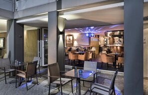 A modern indoor dining area with tables and chairs, a bar area with a counter, and a large mirror on the wall. - Best Western Hotel Zur Post (Bremen)