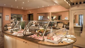 Un espace buffet proposant divers plats, une vitrine réfrigérée et un miroir au mur.
