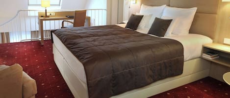 Una habitación de hotel con una cama grande, un escritorio y una silla.