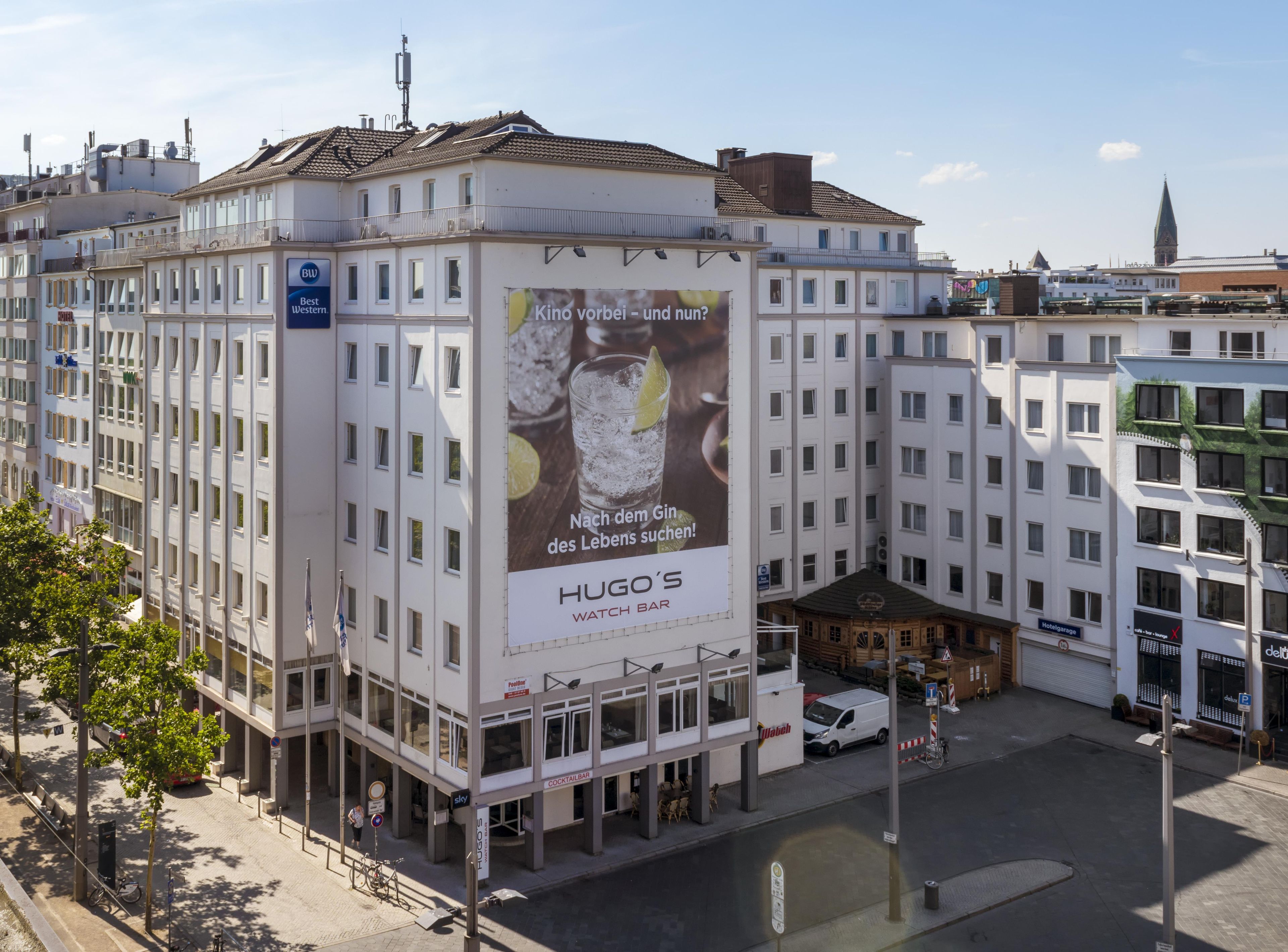 Un edificio de varios pisos con un cartel llamativo que anuncia una relojería.