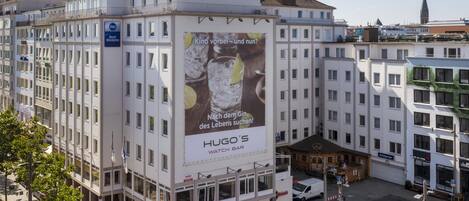 Un edificio de varios pisos con un cartel llamativo que anuncia una relojería.