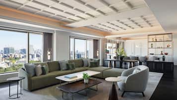 A modern living room with a sectional sofa, a coffee table, and a dining area with a kitchen in the background.