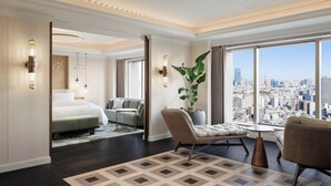 A spacious hotel room with a large bed, a seating area with a view of the city, and a large window offering a panoramic view. - The Westin Tokyo (Tokyo)