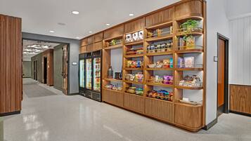 A hallway with a wooden display case filled with snacks and beverages.