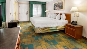 A hotel room with a bed, bedside table, lamp, and a painting on the wall. - La Quinta Inn by Wyndham Albuquerque Northeast (Albuquerque)