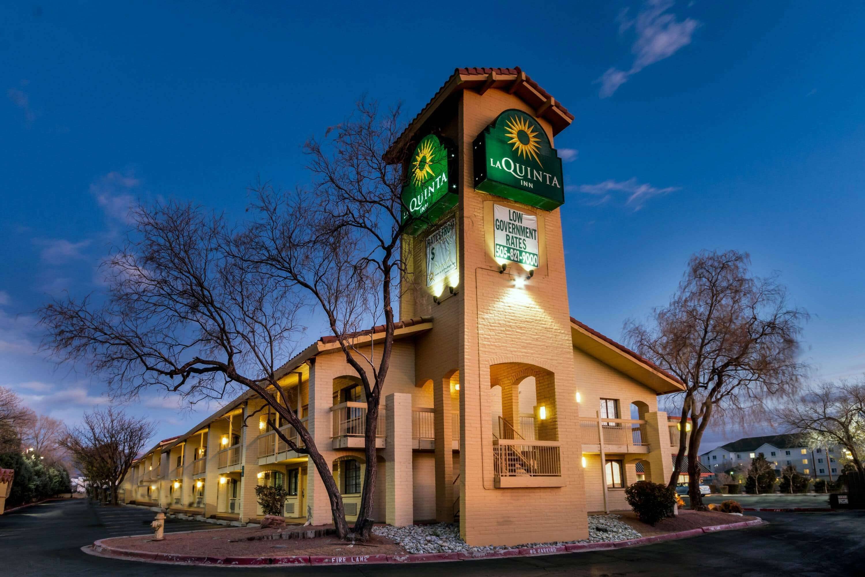 A hotel with a prominent tower, multiple balconies, and a well-lit facade.