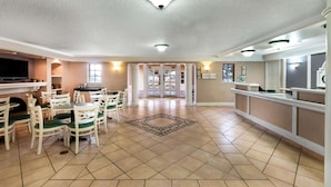A spacious dining area with a tiled floor, white chairs, and a central rug. - La Quinta Inn by Wyndham Albuquerque Northeast (Albuquerque)