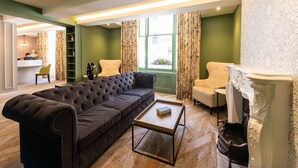 Un salon moderne avec un canapé marron foncé, une table basse en bois et une cheminée blanche.