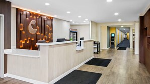 A reception area with a wooden panel wall, a reception desk, and a hallway leading to other rooms. - Comfort Inn & Suites Salt Lake City I-80 I-15 Downtown (Salt Lake City)