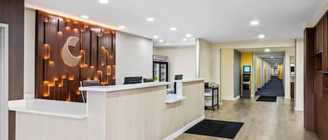 A reception area with a wooden panel wall, a reception desk, and a hallway leading to other rooms.