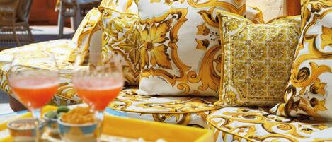 A seating area with patterned cushions and a tray with snacks and drinks.