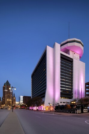 A modern hotel with a prominent "Hyatt Regency" sign, featuring a unique architectural design with a curved section and illuminated pink lighting. - Hyatt Regency Milwaukee (Milwaukee)